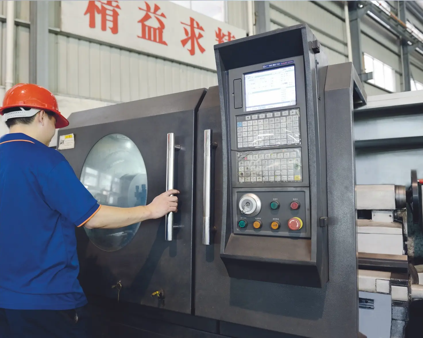 worker operating CNC machine control panel