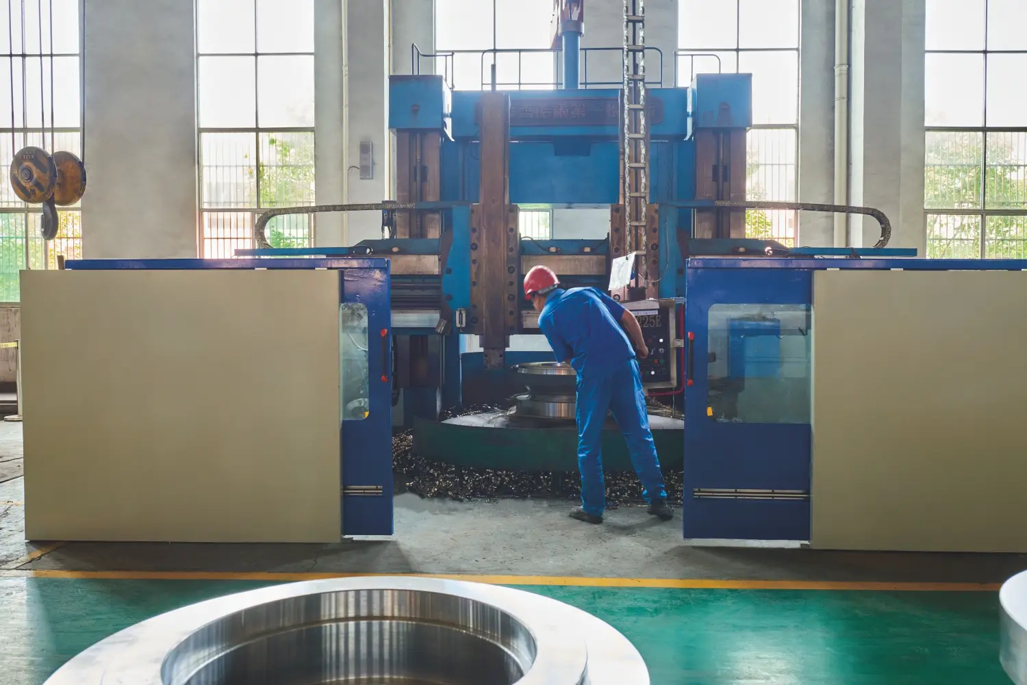 worker operating large milling machine